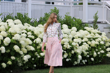Woman standing in front of white hydrangeas and greenery